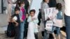 Keluarga yang dievakuasi dari Kabul, Afghanistan, menunggu bus setelah tiba di Bandara Internasional Washington Dulles, di Chantilly, Kamis, 26 Agustus 2021. (Foto: AP/Jose Luis Magana)