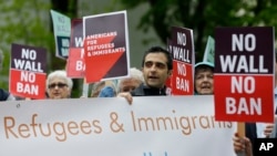 Para pengunjuk rasa mengusung poster dalam sebuah unjukrasa menentang larangan perjalanan yang diperbaharui oleh Presiden Donald Trump di luar gedung pengadilan federal di Seattle, hari Senin, 15 Mei 2017 (foto: AP Photo/Ted S. Warren)