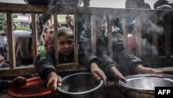 Raseljena palestinska djeca u redu za pomoć u Rafi (Foto: MOHAMMED ABED / AFP)