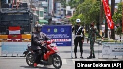 Sejumlah tentara menjaga penyekatan PPKM darurat untuk meredam penyebaran pandemi COVID-19 di Medan, Sumatera Utara, Kamis, 15 Juli 2021. (Foto: Binsar Bakkara/AP)