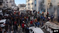 Warga berkumpul setelah sekolah PBB yang digunakan sebagai tempat pengungsian terkena serangan Israel di Rimal, Kota Gaza, Jalur Gaza utara, 14 November 2024. (Foto: AFP)