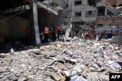 Pegawai kotamadya Gaza dan beberapa pekerja pertahanan sipil memeriksa lokasi tersebut setelah pemboman militer Israel terhadap garasi Kotamadya Gaza di Jalan al-Wahda, di lingkungan al-Daraj di Kota Gaza pada 21 Juni 2024. (Foto: AFP)