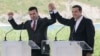 Premijer Grčke, Aleksis Cipras (iza desno) i njegov makedonski kolega Zoran Zaev (iza levo) posmatraju kako ministri inostranih poslova Grčke, Nikos Kotcizis (desno) i Makedonije, Nikola Dimitrov, potpisuju sporazum u mestu Psarades, na grčkoj obali Prespanskog jezera, u Grčkoj, 17. juna 2018.