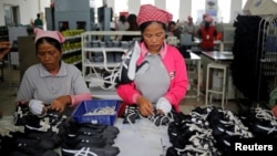 រូបឯកសារ៖ កម្មករ​កំពុង​ដោត​ខ្សែ​ស្បែក​ជើង​ក្នុង​រោងចក្រ​ស្បែក​ជើង​មួយ​របស់​ក្រុមហ៊ុន​តៃវ៉ាន់​ ក្នុង​ខេត្ត​កំពង់ស្ពឺ ថ្ងៃ​ទី៤ ខែកក្កដា ឆ្នាំ​២០១៨។