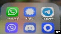 FILE - This picture taken Jan. 22, 2021 in Rennes, France, shows a smartphone screen featuring messaging service applications WhatsApp, Signal, Telegram.