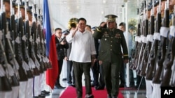 2016年10月25日，菲律宾总统杜特尔特（中左）向军队敬礼，之后他登机前往日本进行为期三天的国事访问。