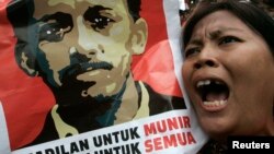 Seorang demonstran meneriakkan slogan sambil membawa poster Munir Said Thalib dalam sebuah protes di luar kantor Badan Intelijen Nasional (BIN), Jakarta. (Foto: Dok)