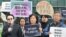 An activist stands with other protesters as he holds a sign that reads “Stop Plastic” in the grounds outside BEXCO, the venue for the fifth session of the UN Intergovernmental Negotiating Committee on Plastic Pollution (INC-5), in Busan on November 25, 20
