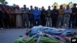 Warga Palestina berdoa di samping jenazah kerabat mereka yang tewas dalam pemboman Israel di Jalur Gaza di Rumah Sakit Al-Aqsa di Deir al-Balah, 19 Desember 2024.