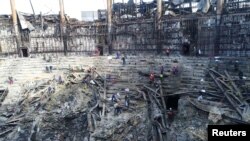 Members of the Russian Emergencies Ministry and workers remove debris inside the burnt-out Crocus City Hall following a deadly attack on the concert venue outside Moscow, in this still image taken from video released March 26, 2024. (Russian Emergencies Ministry/Handout)