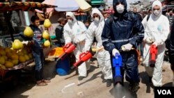 Para petugas menyemprotkan disinfektan di sebuah pasar di kota Gaza, Jalur Gaza (19/3). 