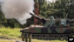 FILE - In this Taiwan Military News Agency photo, a Taiwan artillery gun fires a live round during exercises in Taichung, Taiwan, Sept. 16, 2021. U.S. defense officials are refusing to confirm reports that American forces are in Taiwan, secretly training Taiwanese troops.