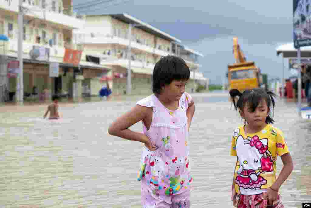 កុមារីពីរនាក់ឈរក្នុងតំបន់ទឹកជន់លិច នៅភូមិព្រែកជ្រៃ សង្កាត់ស្ពានថ្ម ខណ្ឌដង្កោ រាជធានីភ្នំពេញ ថ្ងៃទី១៥ ខែតុលា ឆ្នាំ២០២០។ (ទុំ ម្លិះ/វីអូអេ)