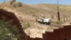 The view from the Mexican side as a U.S. Border Patrol car passes a fence. (G. Flakus/VOA)