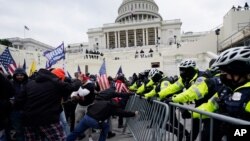 រូបឯកសារ៖ ប៉ូលិសប្រចាំវិមានសភាអាមេរិកកំពុងទប់ទល់នឹងការឡោមព័ទ្ធវិមានសភាដោយក្រុមអ្នកគាំទ្រលោក Donald Trump នៅរដ្ឋធានីវ៉ាស៊ីនតោន កាលពីថ្ងៃទី៦ ខែមករា ឆ្នាំ២០២១។