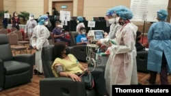 马来西亚梳邦再也市的市民在一个新冠疫苗接种中心接种疫苗。