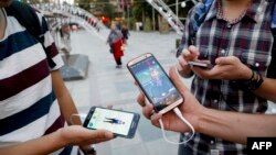 Warga Iran bermain Pokemon Go di Taman Mellat, sebelah utara Teheran (3/8). (AFP/Atta Kenare)