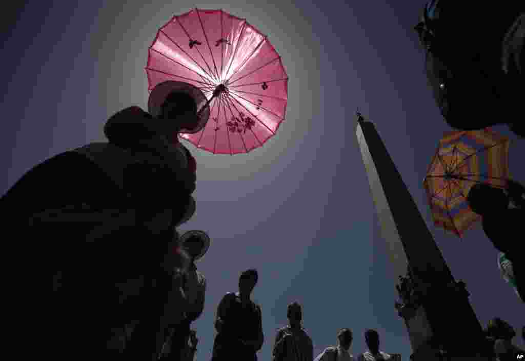 Faithful shelter from sun as they attend the Angelus noon prayer recited by Pope Francis from the window of his studio overlooking St. Peter's Square, at the Vatican.