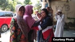 Dwi Wulandari (ketiga dari kiri), buruh migran Indonesia, Minggu siang (19/5) tiba di kampung halamannya di Blitar, Jawa Timur, setelah dibebaskan oleh pihak berwenang Filipina. (Courtesy: Migrant Care) 