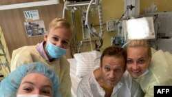 This handout picture posted on Sept. 15, 2020, on the Instagram account of @navalny shows Russian opposition leader Alexei Navalny posing for a selfie with his family at Berlin's Charite hospital. (Photo by Handout / Instagram account @navalny / AFP)