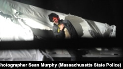  Tsarnaev emerges from the boat. 