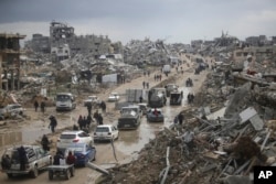 FILE - Cars and pedestrians move along a road amid widespread destruction caused by the Israeli military's ground and air offensive against Hamas in Gaza City's Jabaliya refugee camp, Feb. 7, 2025.