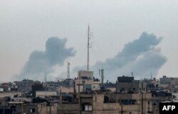 Dim se diže iznad zgrada u Kan Juisu, na jugu Pojasa Gaze, tokom izraelskog bombadrovanja, 20. februara 2024. (Foto: AFP/Mohammed Abed)