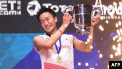Kento Momota berpose dengan pialanya setelah menang melawan Viktor Axelsen di final tunggal putra kejuaraan badminton All England Open di Birmingham, Inggris, 10 Maret 2019. 