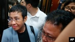Maria Ressa, pimpinan situs berita Filipina "Rappler" dikawal menuju ruang pemeriksaan untuk kasus pencemaran nama baik, Manila, Filipina, 13 Februari 2019.