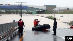 Petugas SAR mencari para korban yang terjebak di dalam terowongan bawah tanah yang terendam banjir di Cheongju, Korea Selatan, Sabtu, 15 Juli 2023. Sebanyak 19 mobil diperkirakan terjebak banjir di dalam terowongan itu setelah hujan lebat. (Foto: Yonhap/AFP)
