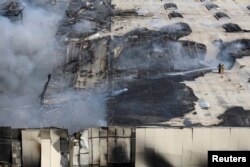 Petugas pemadam kebakaran berupaya memadamkan api di lokasi serangan rudal Rusia di Odesa, Ukraina, 24 Juni 2024. (REUTERS/Stringer)