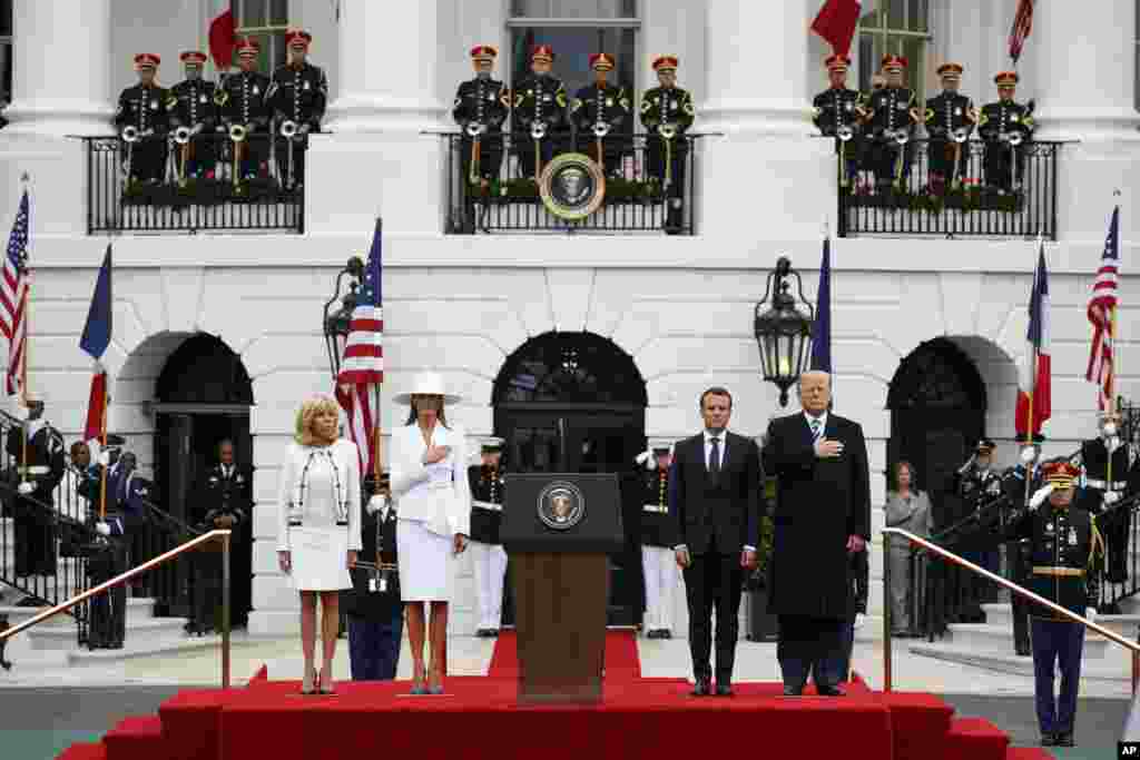 President Donald Trump and first lady Melania Trump stand with French President Emmanuel Macron and his wife Brigitte Macron during a State Arrival Ceremony on the South Lawn of the White House, April 24, 2018, in Washington.