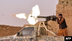 Seorang anggot milisi anti-Taliban menembakan senapan mesin dalam baku tembak dengan pemberontak Taliban di Mukhtar, pinggiran Lashkar Gah, Afghanistan, 28 Maret 2021. 