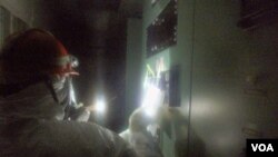 Seorang pekerja memeriksa alat pendeteksi tingkat radiasi di salah satu ruang di PLTN Fukushima, Jepang (23/3).