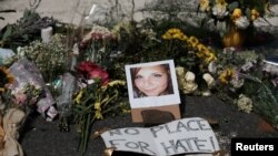Bunga-bunga dan sebuah photo Heather Heyer, korban serangan dengan mobil, teronggok di lokasi tempat kenangan dadakan di Charlottesville, Virgina, 13 Agustus 2017 (foto: REUTERS/Justin Ide)