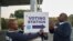Electoral Commission of South Africa (IEC) officials put up a sign outside a polling station in Umlazi on May 29, 2024 during South Africa’s general election.