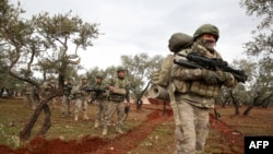 Turkish soldiers gather in the village of Qaminas, about 6 kilometers southeast of Idlib city in northwestern Syria, Feb. 10, 2020.