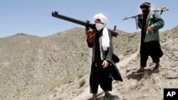 FILE - Afghan Taliban fighters are seen carrying weapons, May 27, 2016.