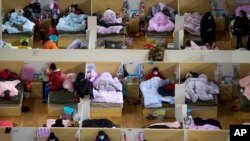 Para pasien yang tertular virus korona beristirahat di rumah sakit darurat di Gelanggang Olahraga Wuhan di Provinsi Hubei, 17 Februari 2020. (Foto: AP)