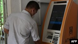 Seorang pria menggunakan ATM Bitcoin di El zonte, tenggara San Salvador, El Salvador (foto: ilustrasi). 