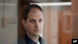 FILE - Wall Street Journal reporter Evan Gershkovich stands in a glass cage in a courtroom at the Moscow City Court in Moscow, Russia, on Oct. 10, 2023. 