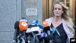 Bintang film porno Stormy Daniels mendekati mikrofon yang dipasang di luar pengadilan federal di New York, untuk memberi keterangan kepada wartawan, 16 April 2018. (Foto: dok).