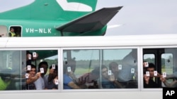 一群寻求庇护者在巴布亚新几内亚的机场降落后出示他们的身份证（资料图）