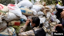 Demonstrant osmatra preko barikada tokom protesta protiv vojnog puča u Jangonu, Mjanmar, 30. marta 2021.