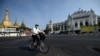 A man wearing a face mask rides a bike on an empty road, 