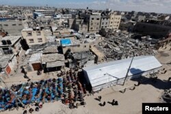 Warga Palestina melaksanakan salat Jumat pertama selama Ramadan di dekat reruntuhan masjid yang hancur, di Rafah, selatan Jalur Gaza, 15 Maret 2024. (Foto: REUTERS/Mohammed Salem)