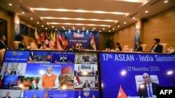 PM India Narendra Modi (tengah, di layar kiri) berbicara dengan PM Vietnam Nguyen Xuan Phuc (layar kanan) pada KTT ASEAN-India yang diadakan secara virtual karena pandemi Covid-19 di Hanoi, 12 November 2020. (Foto: Nhac NGUYEN / AFP)