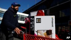 Seorang pria mendorong keranjang penuh barang setelah berbelanja di toko Target pada Black Friday di Brooklyn, N.Y., 24 November 2017. 