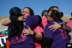 Participants in the annual "Hugs Not Walls" event hug one another on the Rio Grande in Ciudad Juarez, Mexico, Nov. 2, 2024.