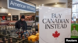 Các kệ hàng trống rỗng với biển "Mua hàng Canada thay thế" sau khi năm thương hiệu rượu hàng đầu của Hoa Kỳ bị loại khỏi danh mục bán tại một Cửa hàng rượu B.C. ở Vancouver, Canada, vào ngày 2/2/2025.